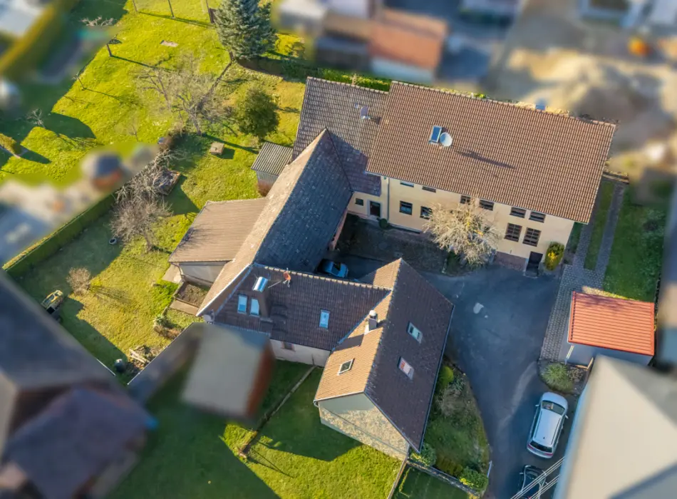 Luftansicht der Immobilie: Anwesen mit großem Wohnhaus und historischem Nebengebäude (Titelbild)