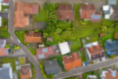 Luftansicht der Immobilie: Sanierungsbedürftiges Wohnhaus mit Charme und großem Grundstück (Foto)