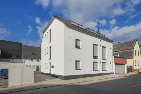 Straßenansicht der Immobilie: Moderne 3,5-Zimmerwohnung in energieeffizientem KfW-55-Haus – ideal für Eigennutzer und Anleger (Foto)