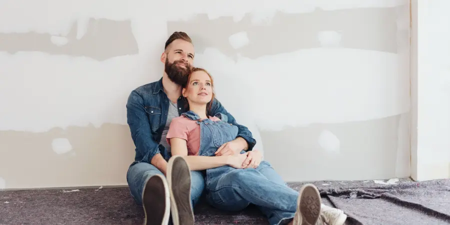 Pärchen sitzt und lehnt sich an der Wand an. Wohnenpur