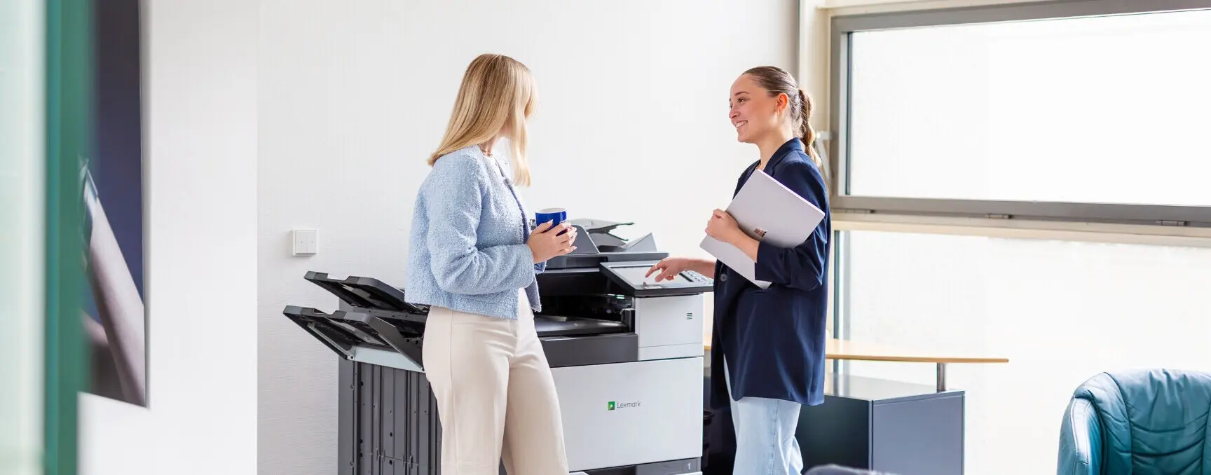 Mitarbeiter stehen am Drucker und unterhalten sich