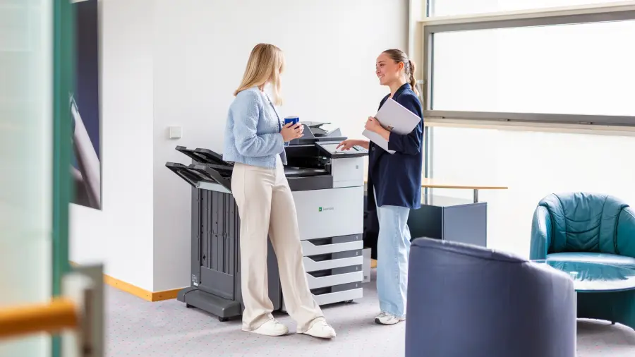 Mitarbeiter stehen am Drucker und unterhalten sich