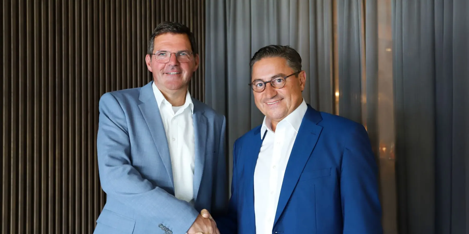 Geschäftsführer Michael Kopf und Co-Geschäftsführer Mathias Spindler schütteln sich die Hand